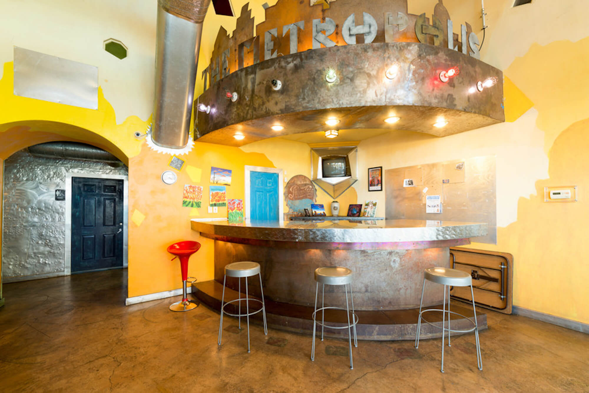 The bright indoor bar at The Metropolis Apartments with barstools